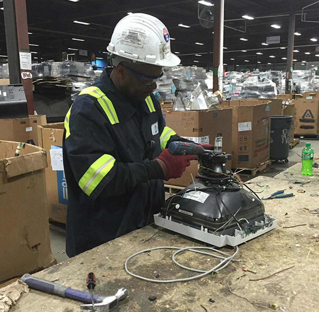 Man working with a machine wearing a hard hat